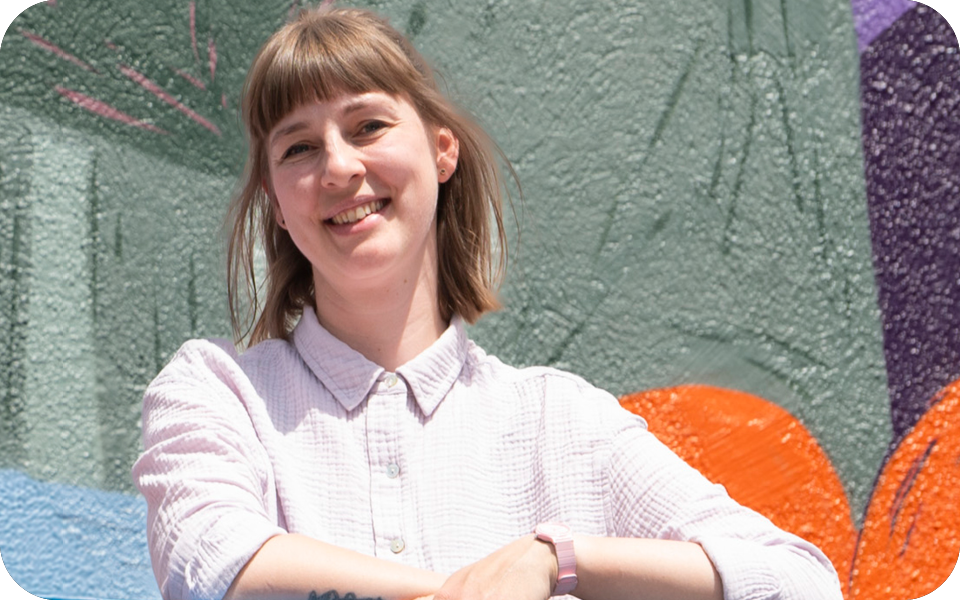 Foto von Ärztin Angelika Radlspöck vor der künstlerischen Hausfassade der Arztpraxis